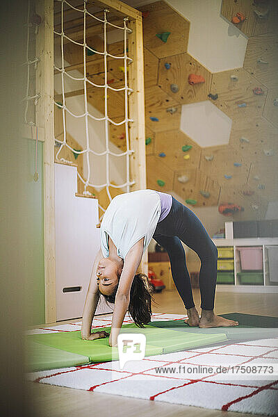 Sportliches Mädchen übt Yoga im Wohnzimmer