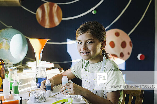 Porträt eines lächelnden Mädchens mit einer Chemikalie bei einem wissenschaftlichen Experiment zu Hause