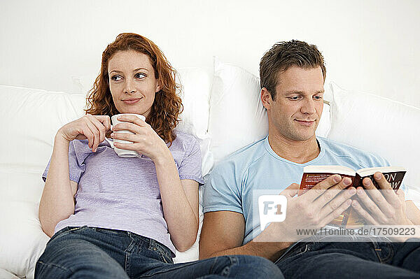 Mann und Frau entspannen zusammen  Frau mit einer Tasse  Mann liest ein Buch.