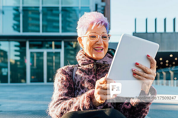 Italy  Fashionable senior woman using tablet in city