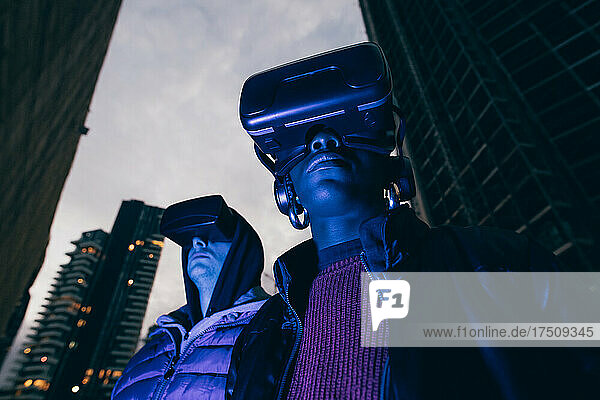 Italy  Couple withVRgoggles standing in city at dusk