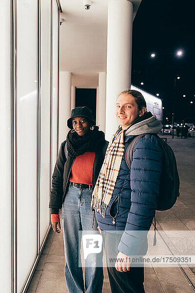 Italy  Portrait of smiling couple standing in city at night