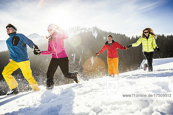 Group of carefree friends running and having fun in snow  Achenkirch  Austria