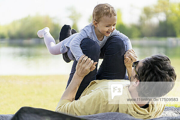 Father playing with his little daughter in a park