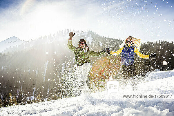 Unbekümmertes Paar läuft durch den Schnee  Achenkirch  Österreich