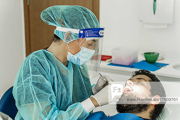 Krankenschwester untersucht männlichen Patienten in der Zahnarztpraxis