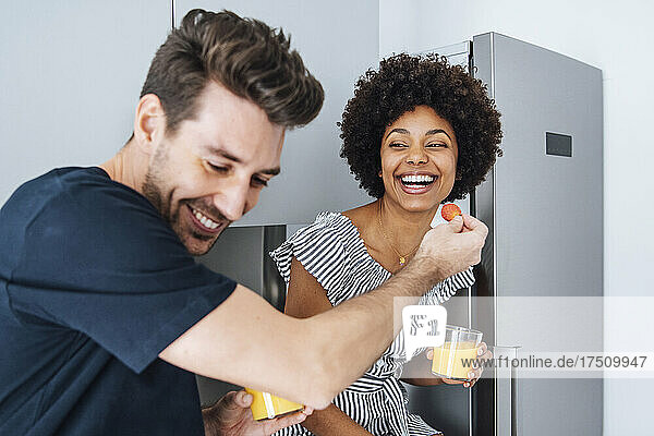 Happy couple having breakfast in kitchen at penthouse