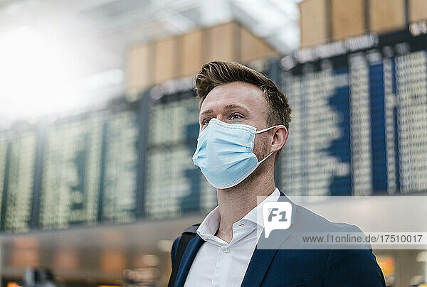 Businessman wearing face mask while looking away in city