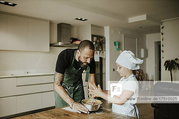 Father and daughter baking cookies at home