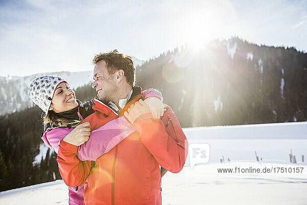 Couple hugging in snowy mountain landscape  Achenkirch  Austria