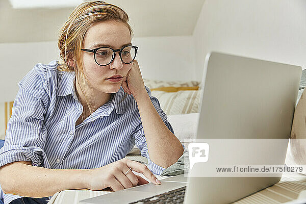 Junge Frau benutzt Laptop zu Hause