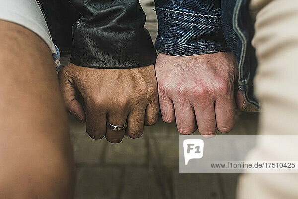 Close-up of gay couple hands on table