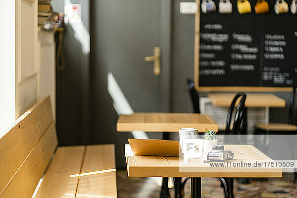Book and camera on wooden table in modern coffee shop