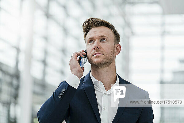 Businessman talking on phone in city