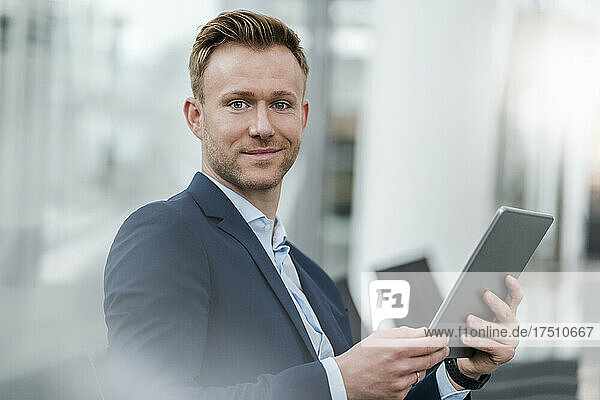 Confident businessman with digital tablet in city
