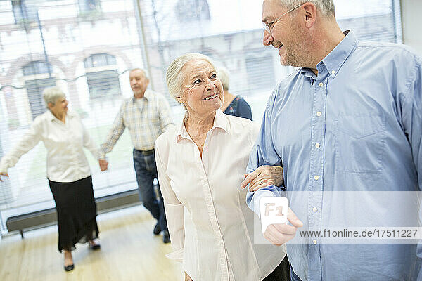 Group of active senior attending dance course in retirement home