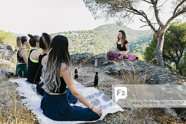 Women practicing yoga in forest