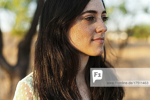 Close-up of thoughtful beautiful woman with long hair looking away during sunset