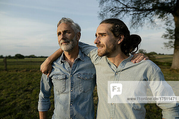 Father and adult son embracing on a meadow in the countryside