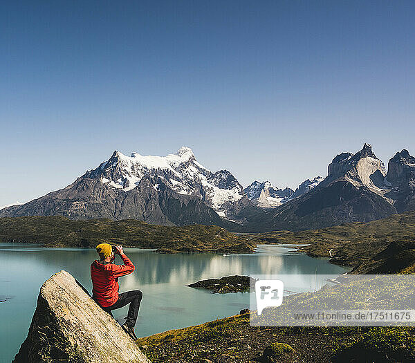 Man looking through binocular at Lake Pehoe in Torres Del Paine National Park  Chile Patagonia  South America