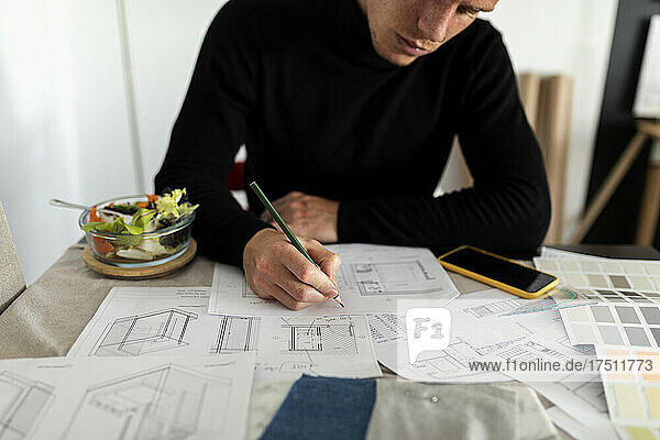 Male architect working on sketch at home office