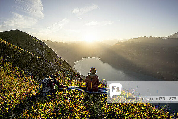 Wanderin sitzt bei Sonnenuntergang auf einem Aussichtspunkt  Augstmatthorn  Schweiz