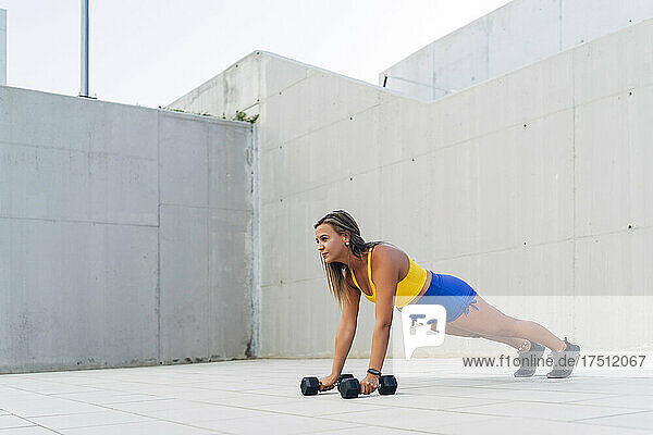 Athletic woman during workout with dumbbells