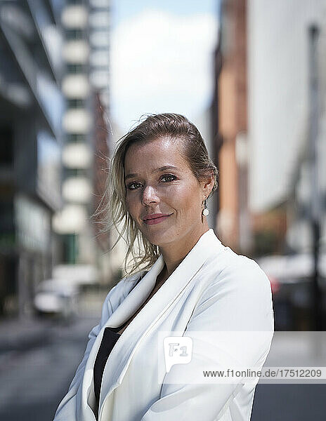 Portrait of confident businesswoman in business district in the city