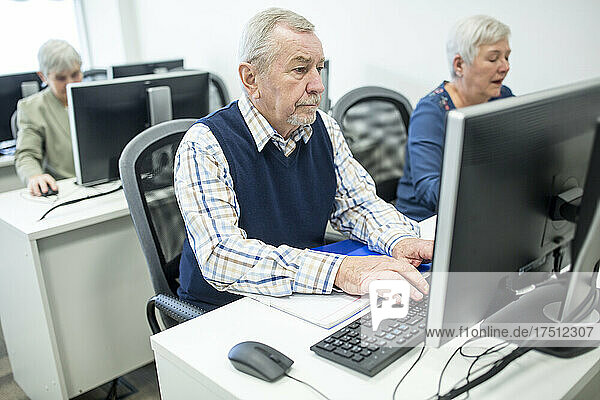 Active seniors attending computer course  working on PC