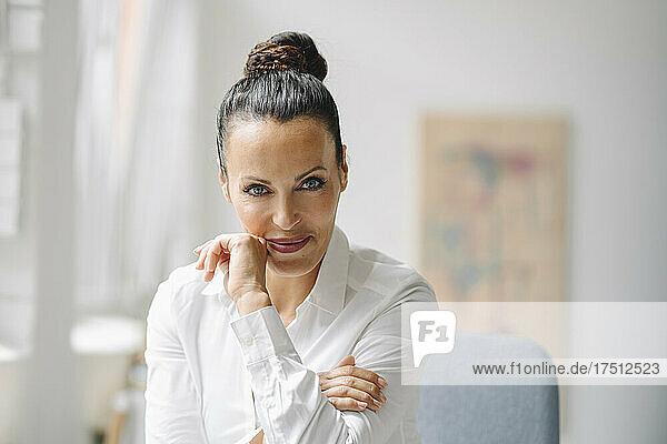 Close-up of smiling female professional sitting in home office