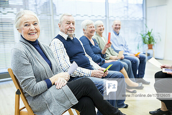 Senioren im Altersheim nehmen an einer Gruppentherapie mit bunten Papierkarten teil