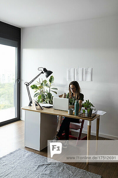 Geschäftsfrau arbeitet am Laptop am Schreibtisch im Heimbüro