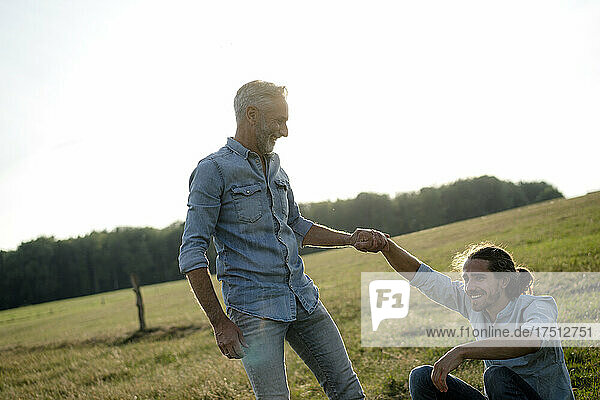 Happy father with adult son on a meadow in the countryside