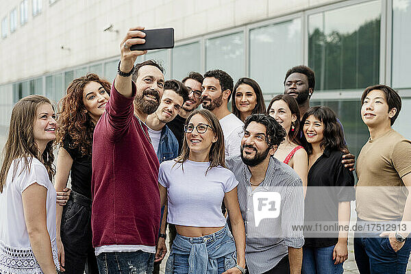Man taking selfie with group of friends in city
