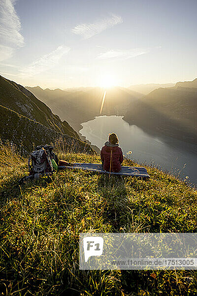 Wanderin sitzt bei Sonnenuntergang auf einem Aussichtspunkt  Augstmatthorn  Schweiz