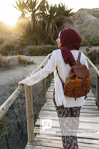 Young tourist woman wearing Hijab on a wooden bridge