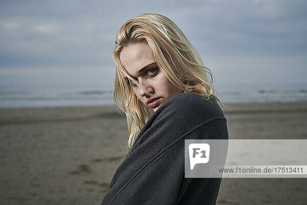 Porträt einer blonden jungen Frau am Strand