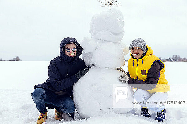 Smiling couple with snowman
