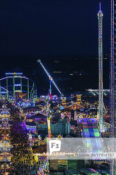 Germany  Bavaria  Munich  Drone view of illuminated amusement park during Oktoberfest at night