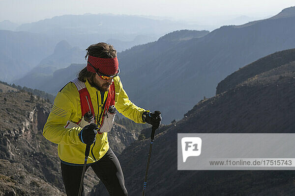 One man wearing yellow using poles hikes up to Pico de Orizaba