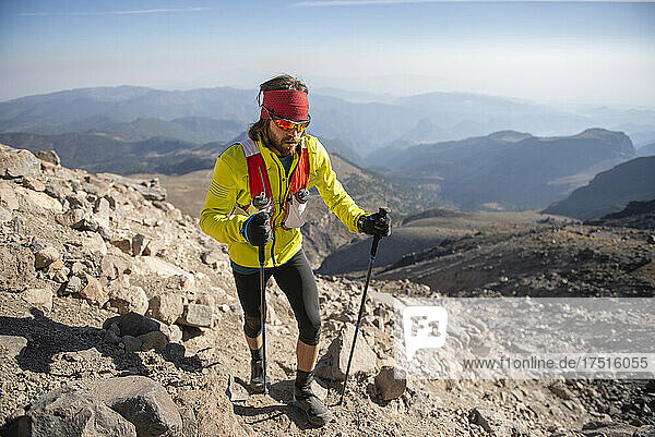 One man with yellow jacket and using poles climbs Pico de Orizaba