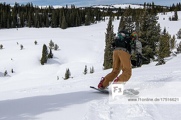 male Snowboarder riding snow in colorado backcountry