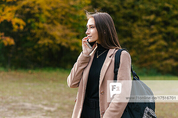 Young brunette girl talking on the mobile phone outdoor