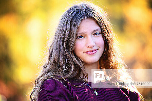 Beautiful happy tween girl outdoors in fall colors.
