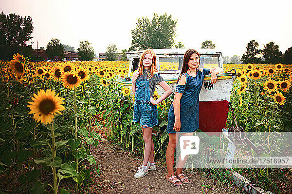 Two happy tween girls in a sunflower field.
