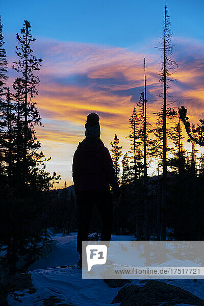 Silhouette woman on snow covered mountain at sunset