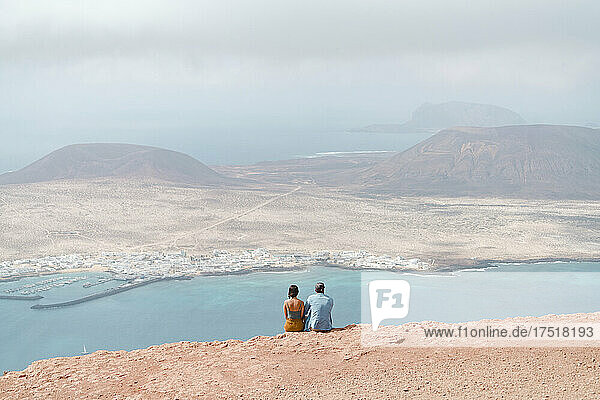 Couple relaxing on top of cliff in Mirador del Rio  Lanzarote.