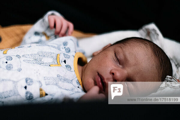 Newborn baby sleeping peacefully in his carriage.