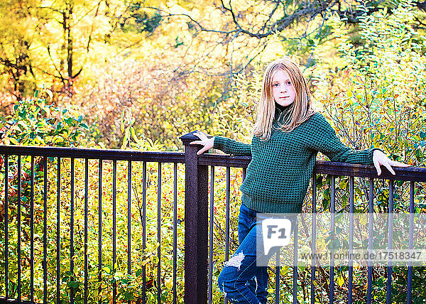 Pretty tween girl with red hair outdoors in fall colors.