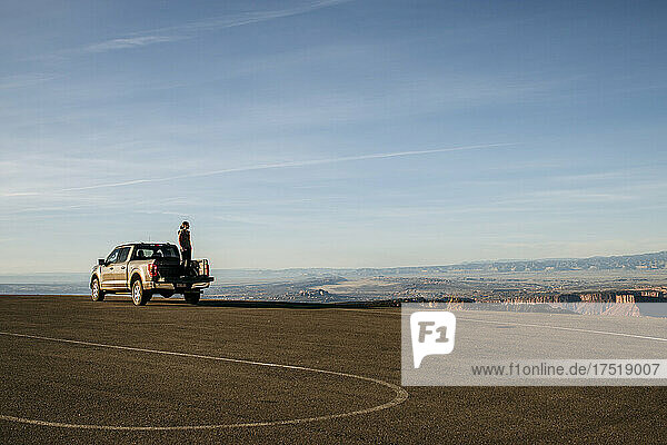 Woman stands in bed of pickup truck looking at view  Moab  Utah.